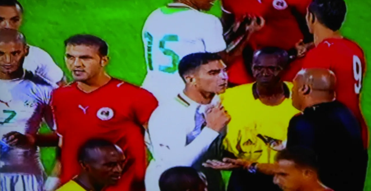 Libya-Algeria3 The referee and some Algerian players as they try to convince Albrich (Libya’s coach) and the Libyan players not to leave the field following abusive and intimidating chants from the Algerian crowd. (Photo: Mohamed Assed)