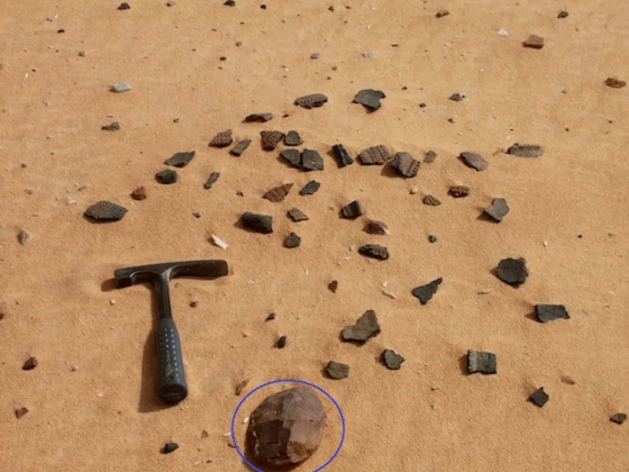 Scattered pottery and a hand axe