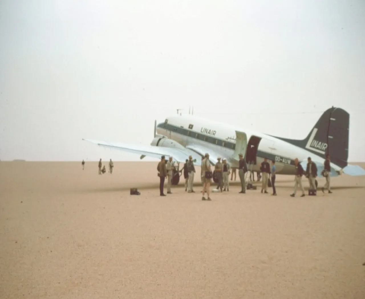 Figure 4: PESL participants in one of the field excursions in the Libyan Sahara in the 1960s. The Linair plane was an airliner used in Libya at the time (a DC-3) which could land without a proper airstrip (here on a flat gravel plain 'serir' surface).