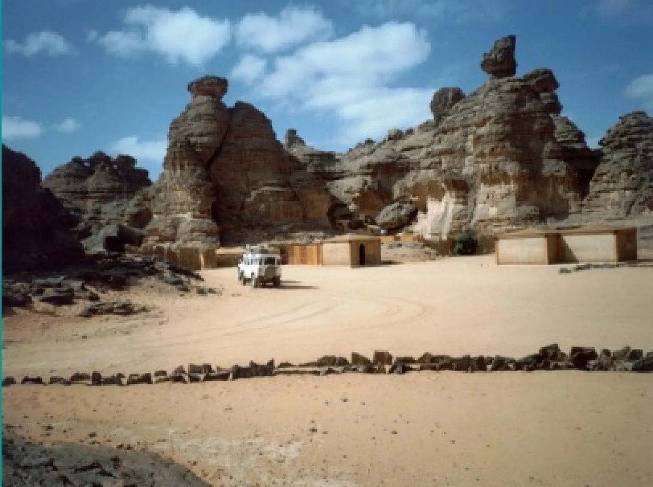 Figure 5:  A beautiful landscape within the area of Tadrart Akakus. This luxury camp was erected within the Akakus World Heritage territory and was built and operated by a foreign tour company.  For several years (till the camp was moved to the other side of the mountains) accommodation in it was limited to the clients of that company. Not only was the camp erected on Heritage land and made off-limits to the general public, but sadly, a lot of prehistoric lithics were also collected from the neighboring area and sold to the tourists as souvenirs, and some were even used to decorate the exclusive camp. No one has yet been penalised for this abuse of a UNESCO World Heritage site (Photo: M. J. Salem).